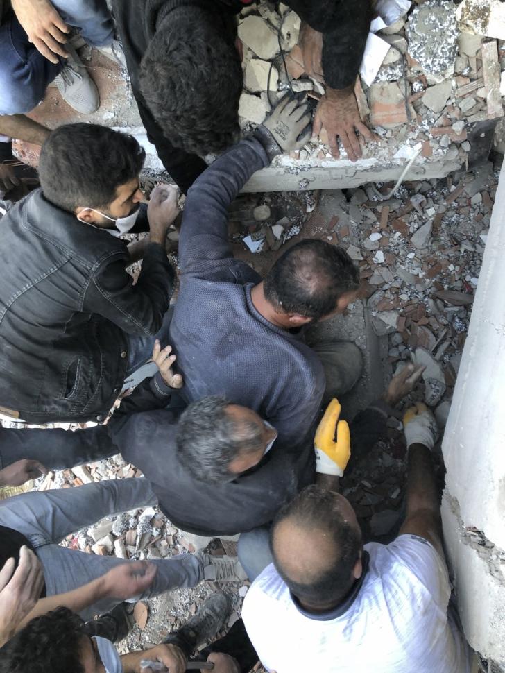 Homens trabalham no resgate de sobreviventes após desabamento de prédio na Turquia durante forte terremoto no Mar Egeu nesta sexta-feira (30) — Foto: Ismail Gokmen/AP