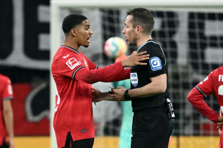 Atacante Adli conversa com o árbitro do jogo entre Bayer Leverkusen e Bayern de Munique — Foto: Getty Images